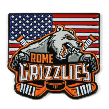 A trading pin with a bear, two hockey sticks, and 'Rome Grizzlies' text on an American flag background.