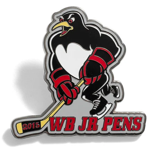 Custom trading pin for the WB Jr Pens hockey team, featuring a fierce black and white penguin in red gloves and skates, holding a yellow hockey stick. The text “WB JR PENS” is in bold red letters along the bottom with “2015” on the stick blade.